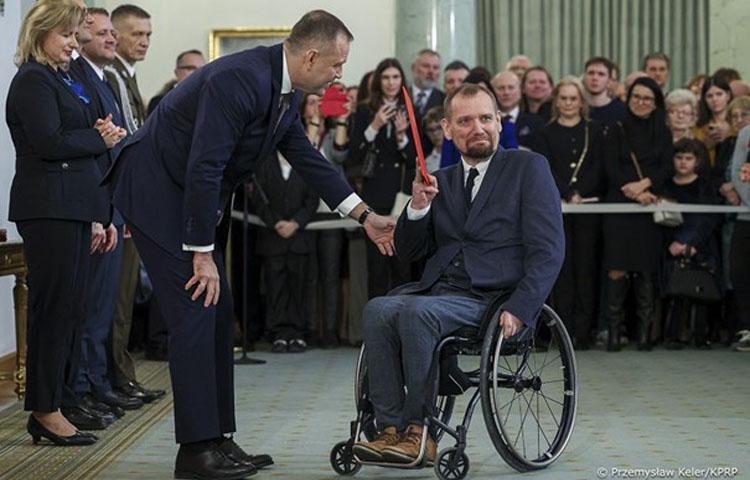 Zdjęcie z wręczenia nominacji profesorskiej prof. Maciejowi Sydorowi. Na zdjęciu z lewej strony Prezydent RP z prawej prof. Maciej Sydorowicz. W tle uczestnicy uroczystości.