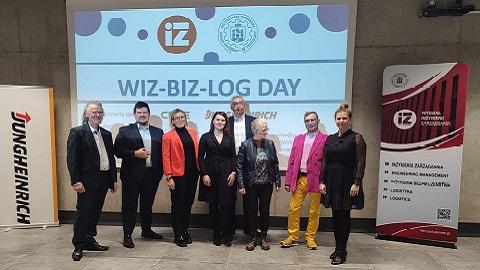 Zdjęcie uczestników na tle plakatu wiz-biz-log day