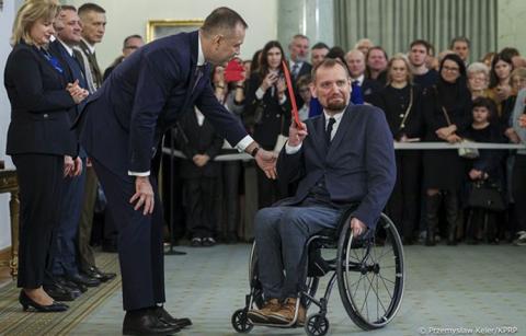 Zdjęcie z wręczenia nominacji profesorskiej prof. Maciejowi Sydorowi. Na zdjęciu z lewej strony Prezydent RP z prawej prof. Maciej Sydorowicz. W tle uczestnicy uroczystości.