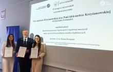 Agnieszka i Aleksandra Krzyżanowskie wraz z promotorem dr inż. Romanem Domańskim odbierają wyróżnienie za swoją pracę inzynierską