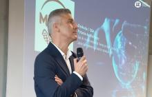 Zdjęcie z sali podczas prelekcji. Na pierwszym planie gość pan Ireneusz Kozber, Dyrektor Logistyki w Millano Group na tle ekranu gdzie jest wyświetlana prezentacja